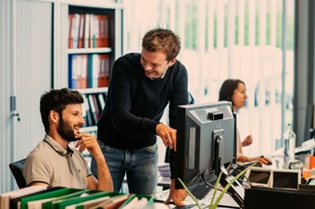 Jonge collega's overleggen aan hun bureau