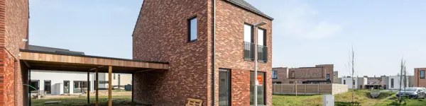 Huis in Maaseik moderne nieuwbouw met rode steen en zadeldak