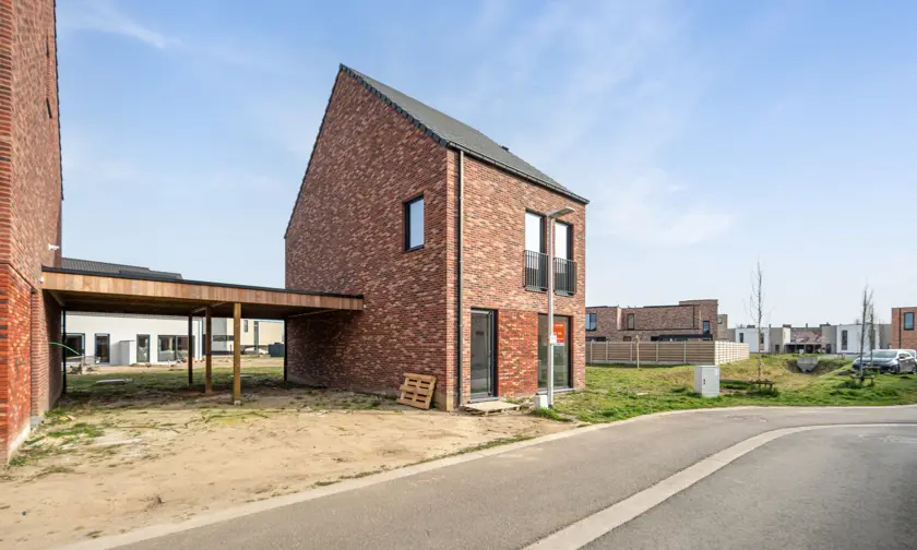 Huis in Maaseik moderne nieuwbouw met rode steen en zadeldak