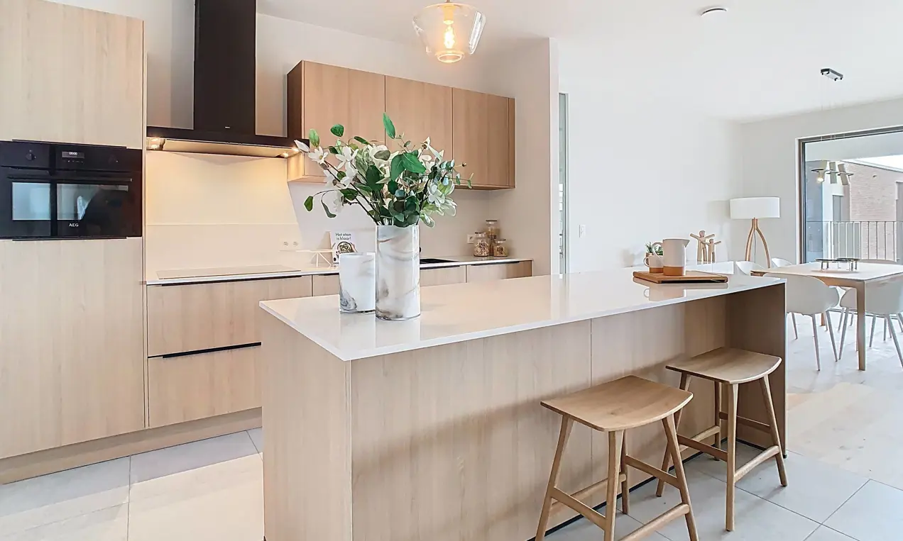 ruime, lichte keuken met keukeneiland, veel lichtinval, parket en grote raampartijen aan de private daktuin, grenzend aan een ruim terras - afgewerkt kijkappartement 